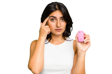 Young Indian woman holding a car keys isolated pointing temple with finger, thinking, focused on a task.