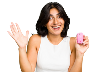 Young Indian woman holding a car keys isolated receiving a pleasant surprise, excited and raising hands.