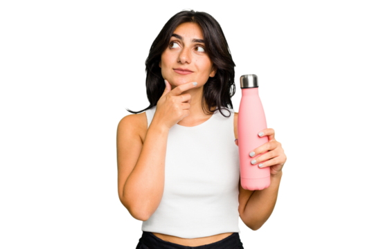 Young Indian woman holding a thermo isolated looking sideways with doubtful and skeptical expression.