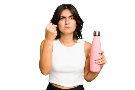 Young Indian woman holding a thermo isolated showing fist to camera, aggressive facial expression.