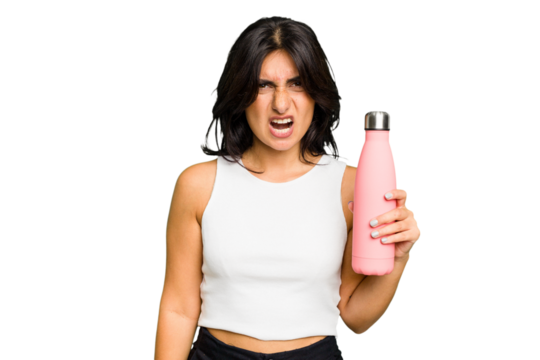 Young Indian woman holding a thermo isolated screaming very angry and aggressive.