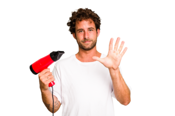 Young caucasian man holding an hairdryer isolated smiling cheerful showing number five with fingers.
