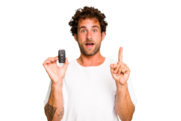 Young caucasian man holding car keys isolated having some great idea, concept of creativity.