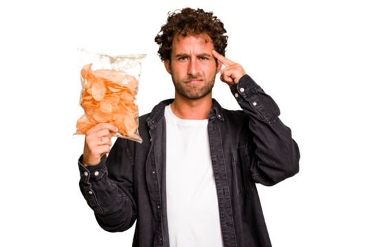 Young caucasian man holding crips isolated showing a disappointment gesture with forefinger.