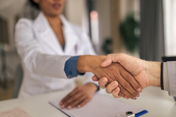 Two diverse hospital workers, starting a meeting with a handshake.