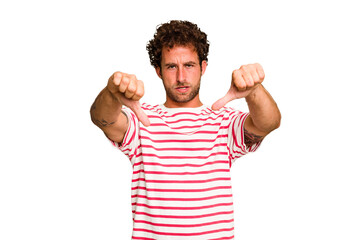 Young caucasian curly hair man isolated Young caucasian man with curly hair isolated showing thumb down and expressing dislike.