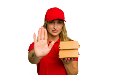 Young caucasian delivery woman holding a burger isolated on green chroma background standing with outstretched hand showing stop sign, preventing you.