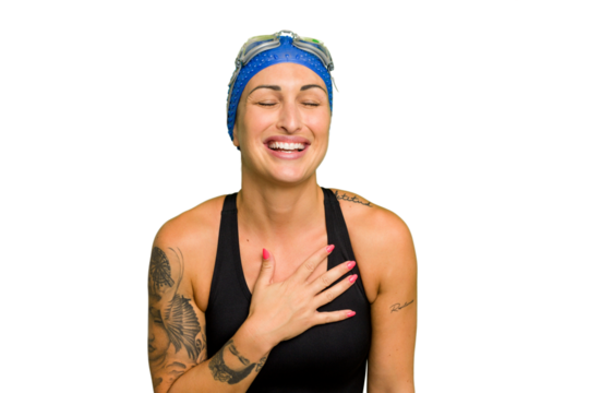 Young caucasian swimmer woman isolated on green chroma background laughs out loudly keeping hand on chest.