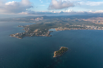 Aerial photography, island on sea with turquoise water and blue cloudy sky