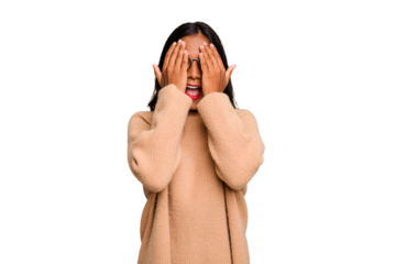 Young Indian woman isolated having fun covering half of face with palm.
