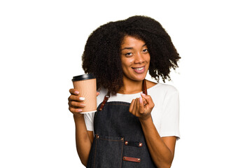 Young african american woman barista holding a takeaway coffee pointing with finger at you as if inviting come closer.