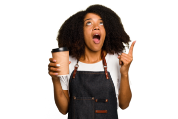 Young african american woman barista holding a takeaway coffee pointing upside with opened mouth.