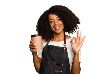 Young african american woman barista holding a takeaway coffee cheerful and confident showing ok gesture.