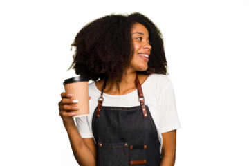 Young african american woman barista holding a takeaway coffee looks aside smiling, cheerful and pleasant.