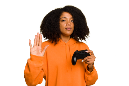Young African American woman holding a game controller isolated standing with outstretched hand showing stop sign, preventing you.