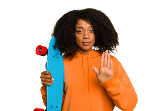 Young skater African American woman holding a little skate isolated standing with outstretched hand showing stop sign, preventing you.