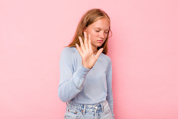 Caucasian teen girl isolated on pink background rejecting someone showing a gesture of disgust.