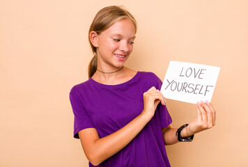 Little caucasian woman holding love yourself placard isolated on beige background