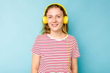 Young caucasian woman wearing headphones isolated on blue background happy, smiling and cheerful.