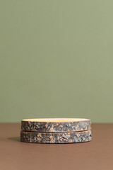 Wooden slice podium on a brown table on a green background. Premium empty scene for product promotion, beauty, natural eco cosmetic. Showcase, display case.