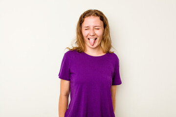 Young caucasian woman isolated on white background funny and friendly sticking out tongue.