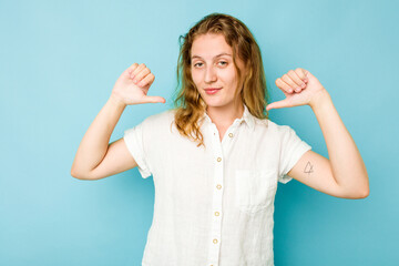 Young caucasian woman isolated on blue background feels proud and self confident, example to follow.