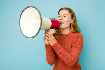 Young caucasian woman holding megaphone isolated on blue background