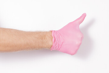 male hand holds in a pink rubber glove on a white