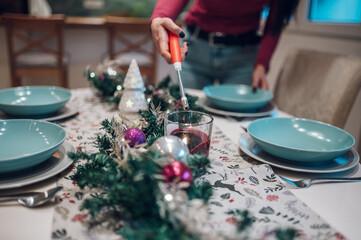 Middle aged woman decorating and setting the table for Christmas dinner