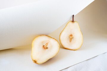 Ripe juicy pears on white color linen tablecloth.