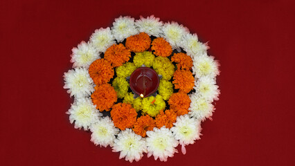 Happy Diwali. Traditional symbols of Indian festival of light. Burning diya oil lamps and flowers on red background. Copy space.