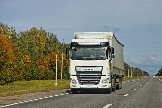 White heavy semi truck DAF drive on countryside highway road  at autumn day. Goods import in Europe