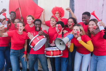 Heterogeneous group of fans enthusiastically cheering their team ahead of the competition