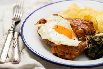typical portuguese smoked sausage alheira with fried egg, chips