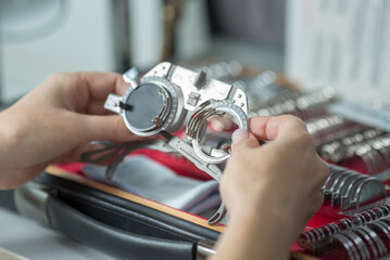 a young girl holds in her hands a trial eyeglass frame, the concept of glasses selection, vision correction. hands close-up.