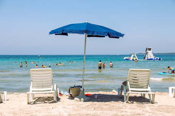 Two beach chairs under an umbrella