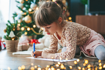 Little girl writing a letter to Santa Claus