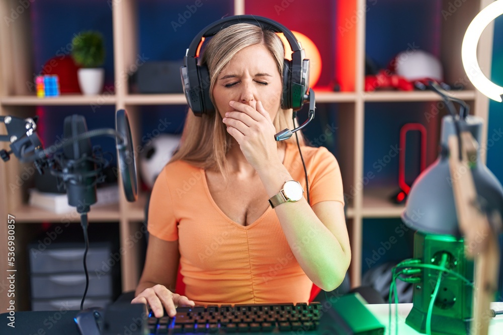 Canvas Prints young woman playing video games bored yawning tired covering mouth with hand. restless and sleepines