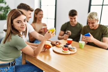 Group of young friends smiling happy having breakfast sitting on the table at home.