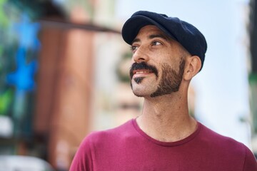 Young hispanic man smiling confident looking to the sky at street