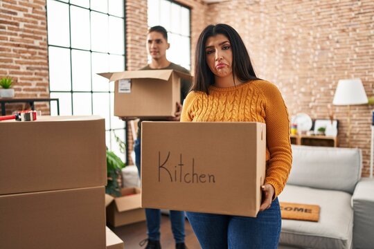 Young couple moving to a new home with cardboard boxes depressed and worry for distress, crying angry and afraid. sad expression.