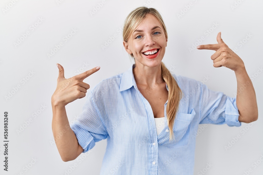 Poster Beautiful blonde woman standing over white background smiling cheerful showing and pointing with fingers teeth and mouth. dental health concept.