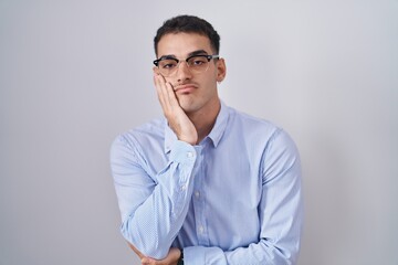 Handsome hispanic man wearing business clothes and glasses thinking looking tired and bored with depression problems with crossed arms.