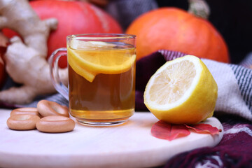 Autumn tea, warming vitamin drink with lemon and ginger. Autumn mood, composition with ripe pumpkins, bagels and lemon tea, still life