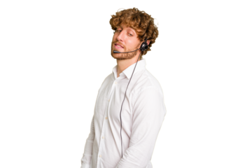 Telemarketer man working with a headset isolated on green chroma background looks aside smiling, cheerful and pleasant.