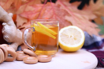 Delicious tea with lemon, a bunch of bagels and autumn foliage on the background, selective focus of the photo.