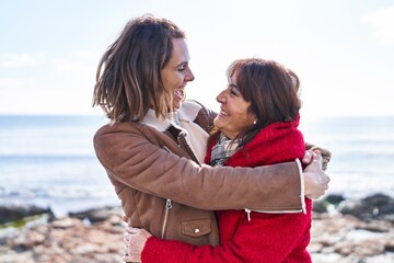 Two women mother and daughter hugging each other at seaside