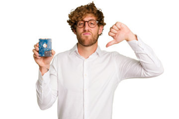 Young caucasian informatic man holding a hard drive isolated on white background showing a dislike gesture, thumbs down. Disagreement concept.