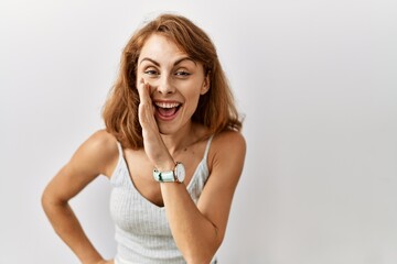 Beautiful caucasian woman standing over isolated background hand on mouth telling secret rumor, whispering malicious talk conversation