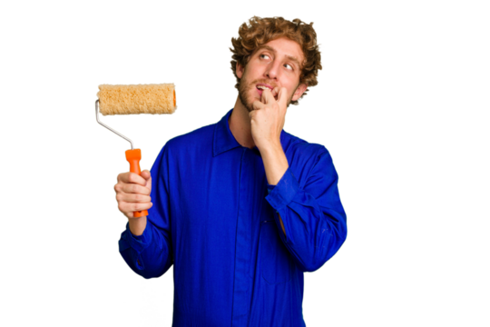Young painter man holding a roll isolated on white background relaxed thinking about something looking at a copy space.